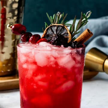 Blackberry Smash Cocktail with beautiful garnishes on a white table