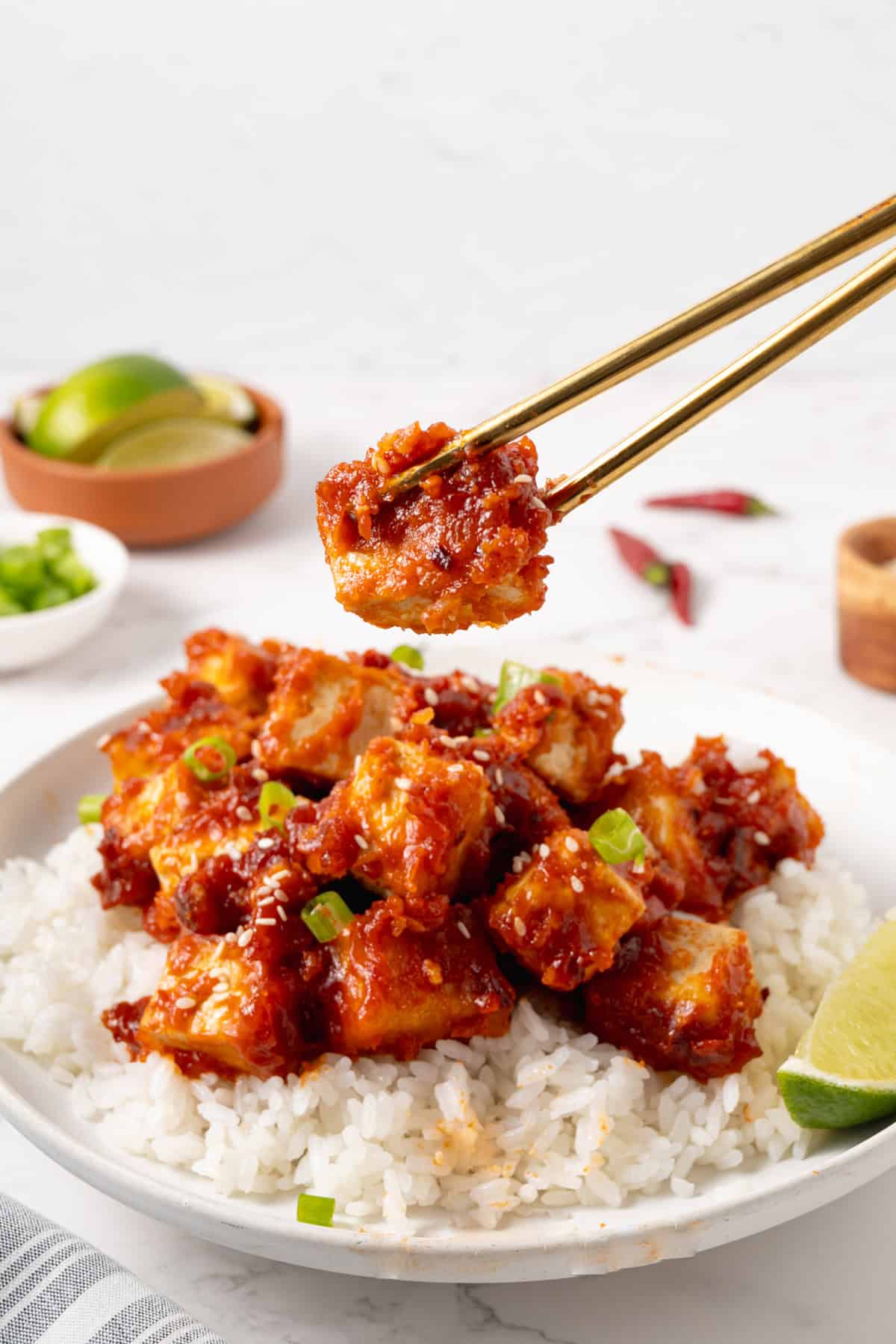 chopsticks holding up a piece of general tso's tofu