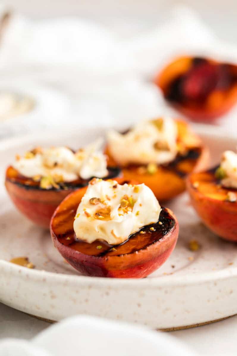 a plate of grilled peaches with vegan mascarpone