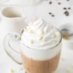 white chocolate latte topped with whipped cream and white chocolate chips