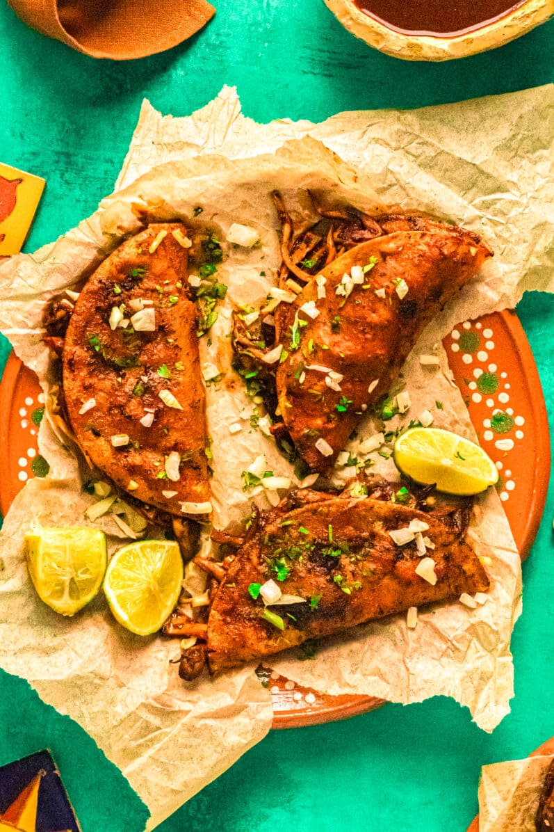 3 vegan birria tacos on a Mexican style plate
