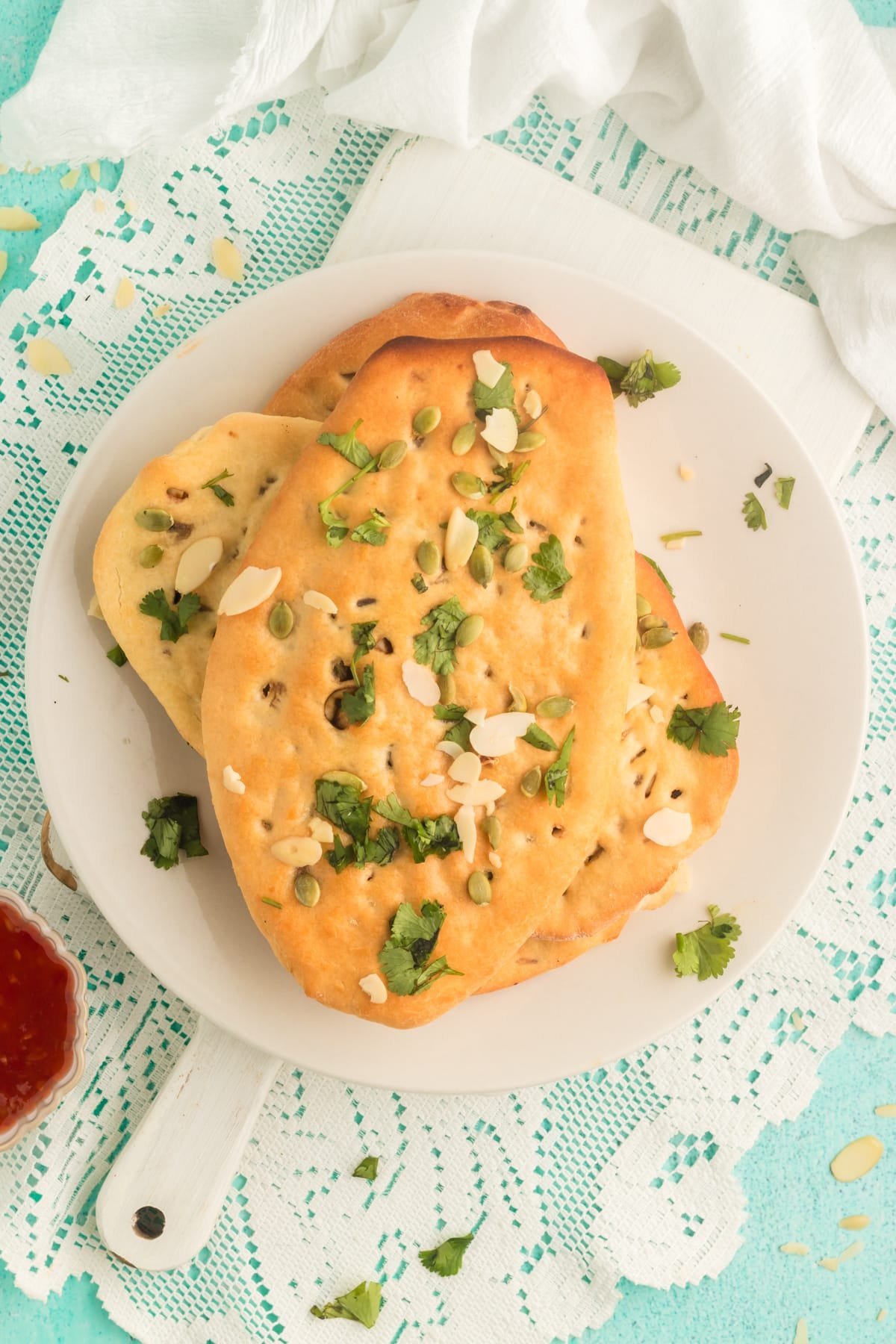 overhead view of a stack of Kashmiri Naan on a white plate