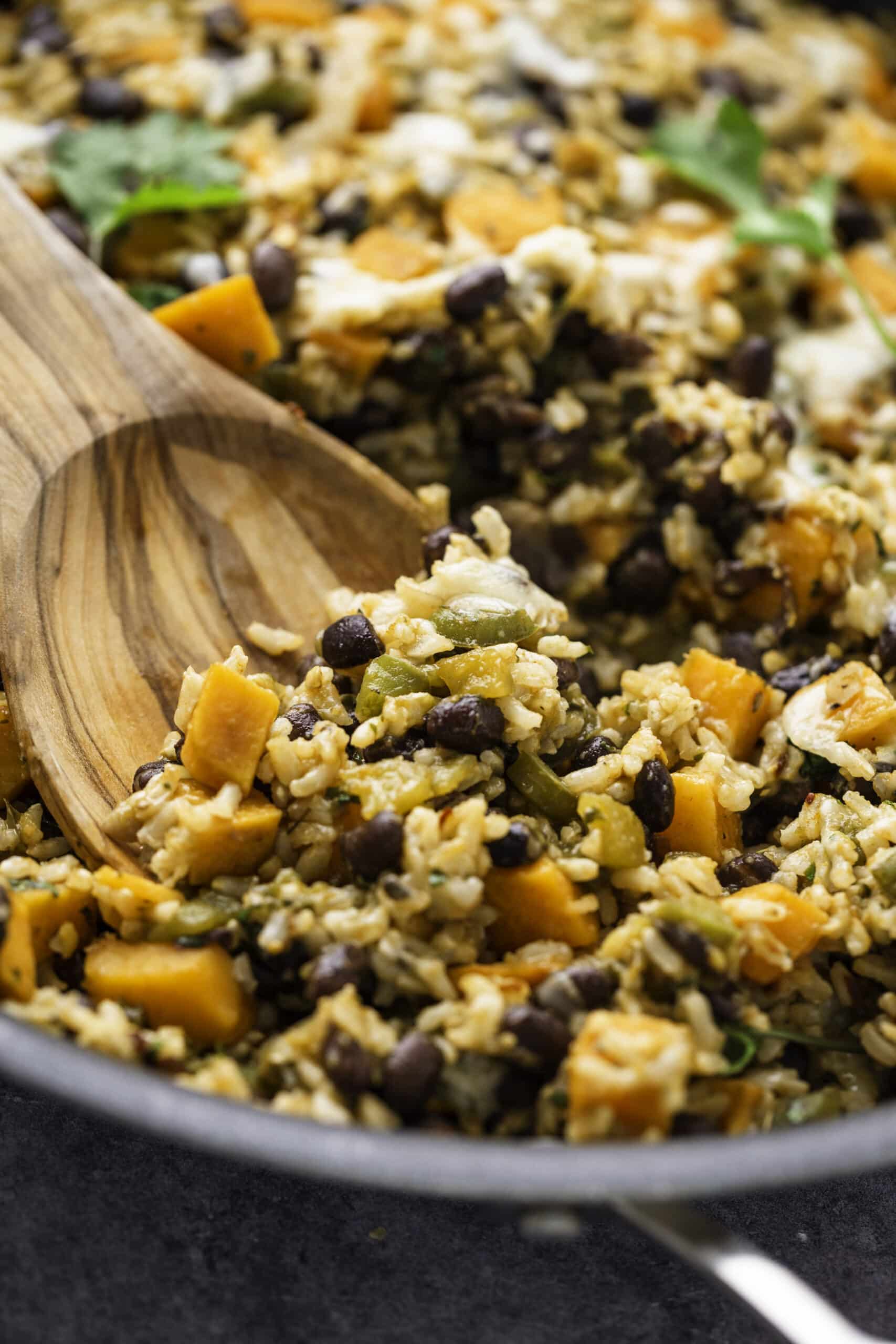 Close up of a spoonful of sweet potatoes, rice and black beans