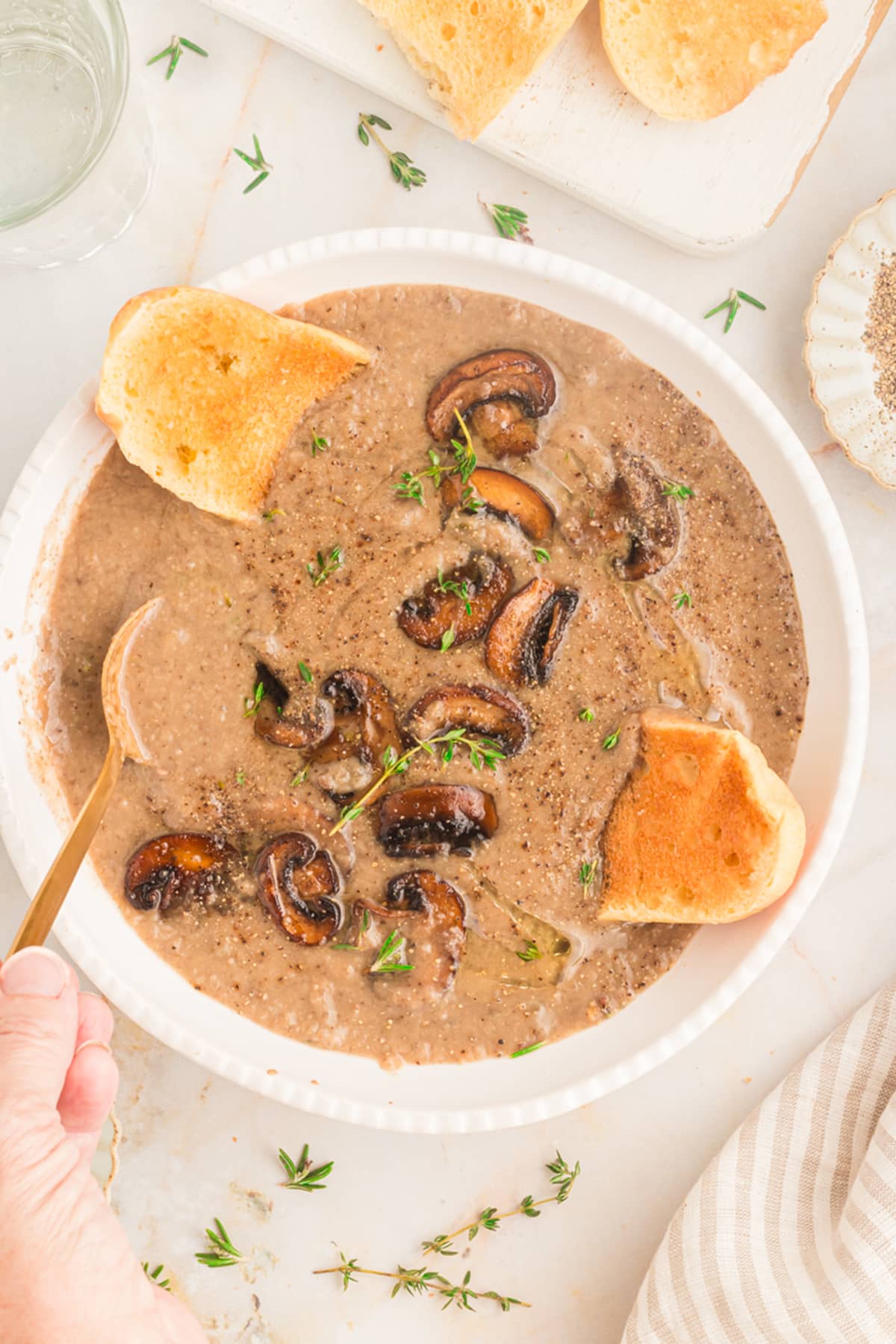 overhead view of vegan cream of mushroom soup in a white bowl