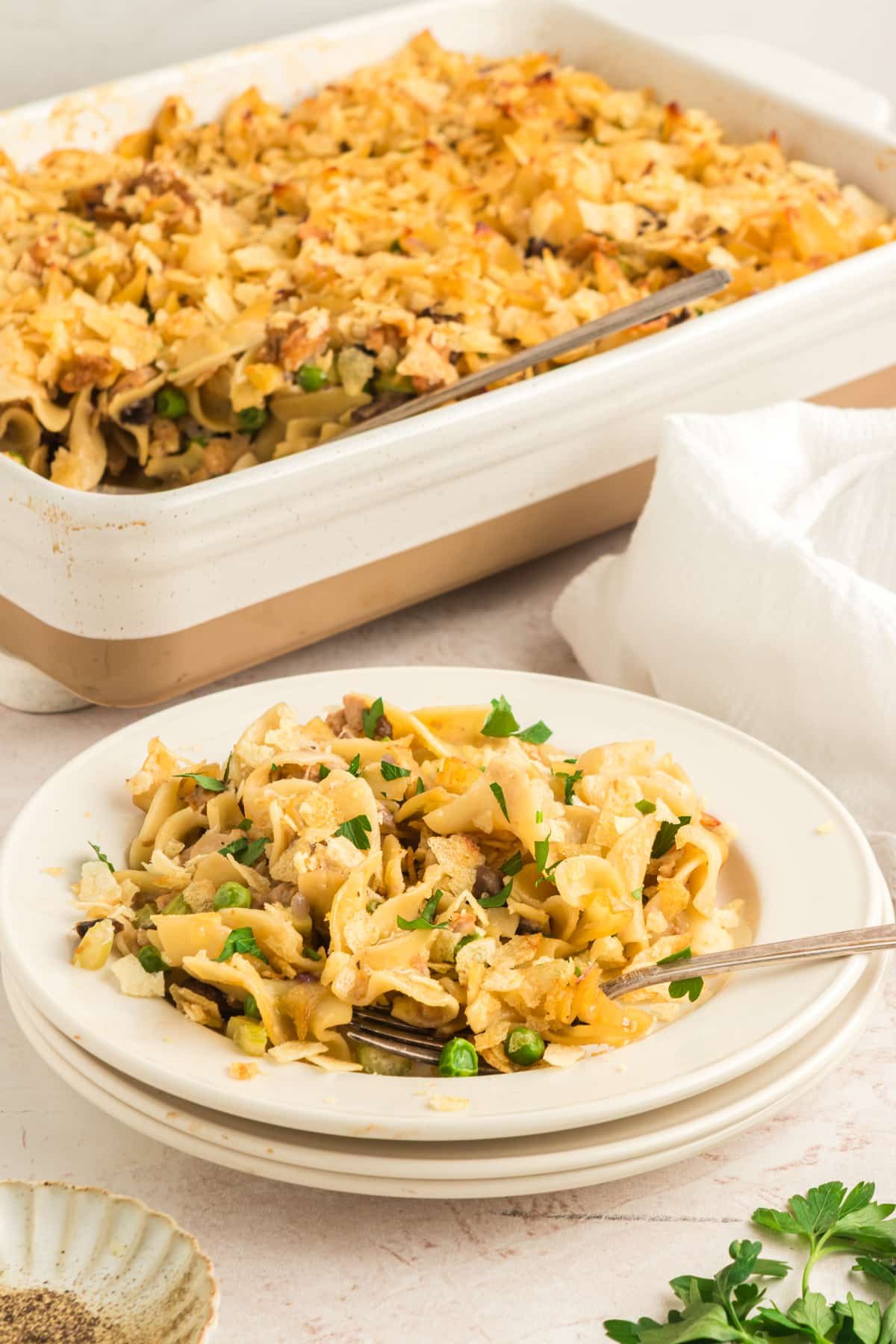 side view of plate of vegan tuna casserole with casserole dish in background