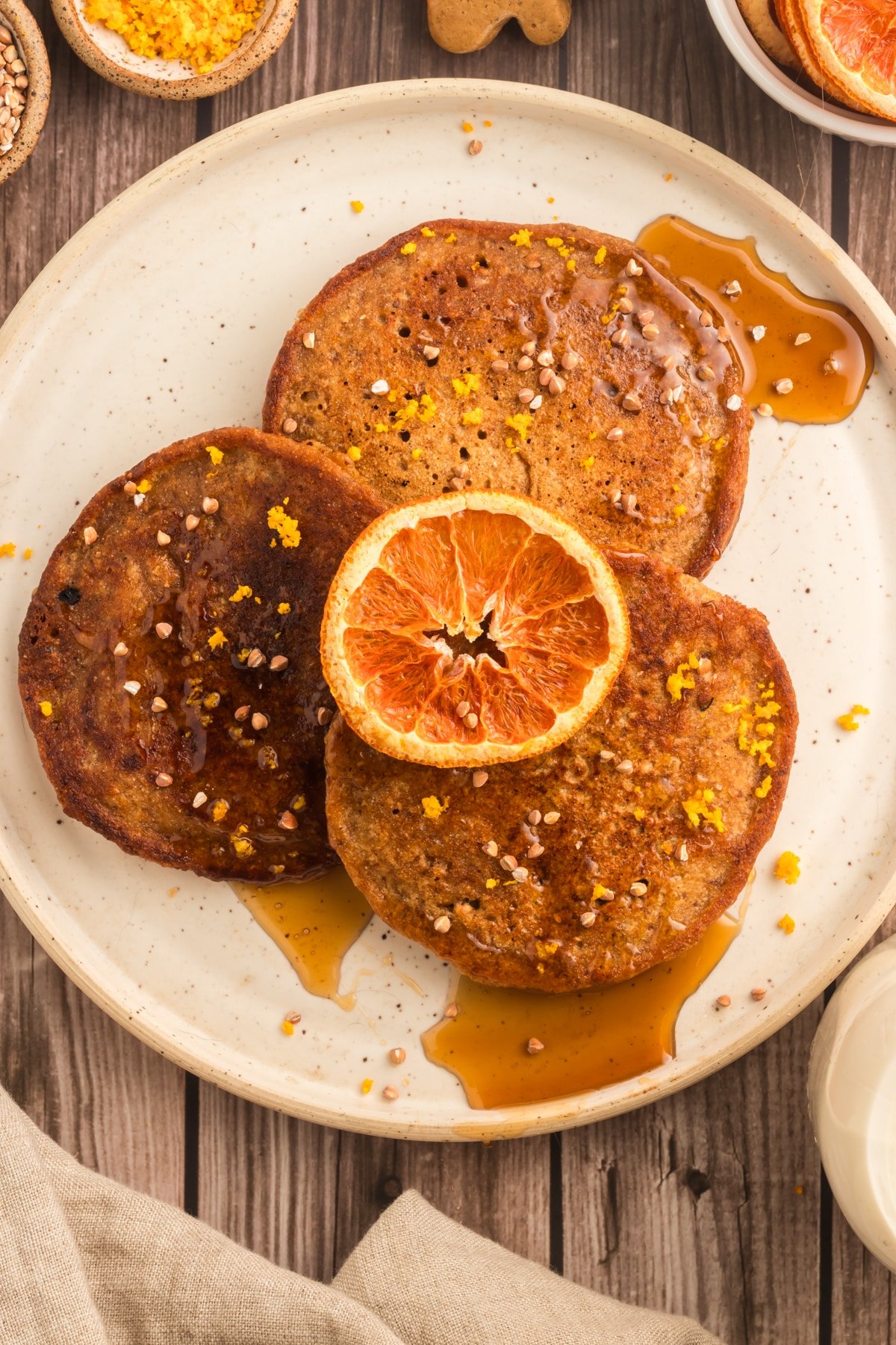 3 gingerbread pancakes on a white plate on a wood table