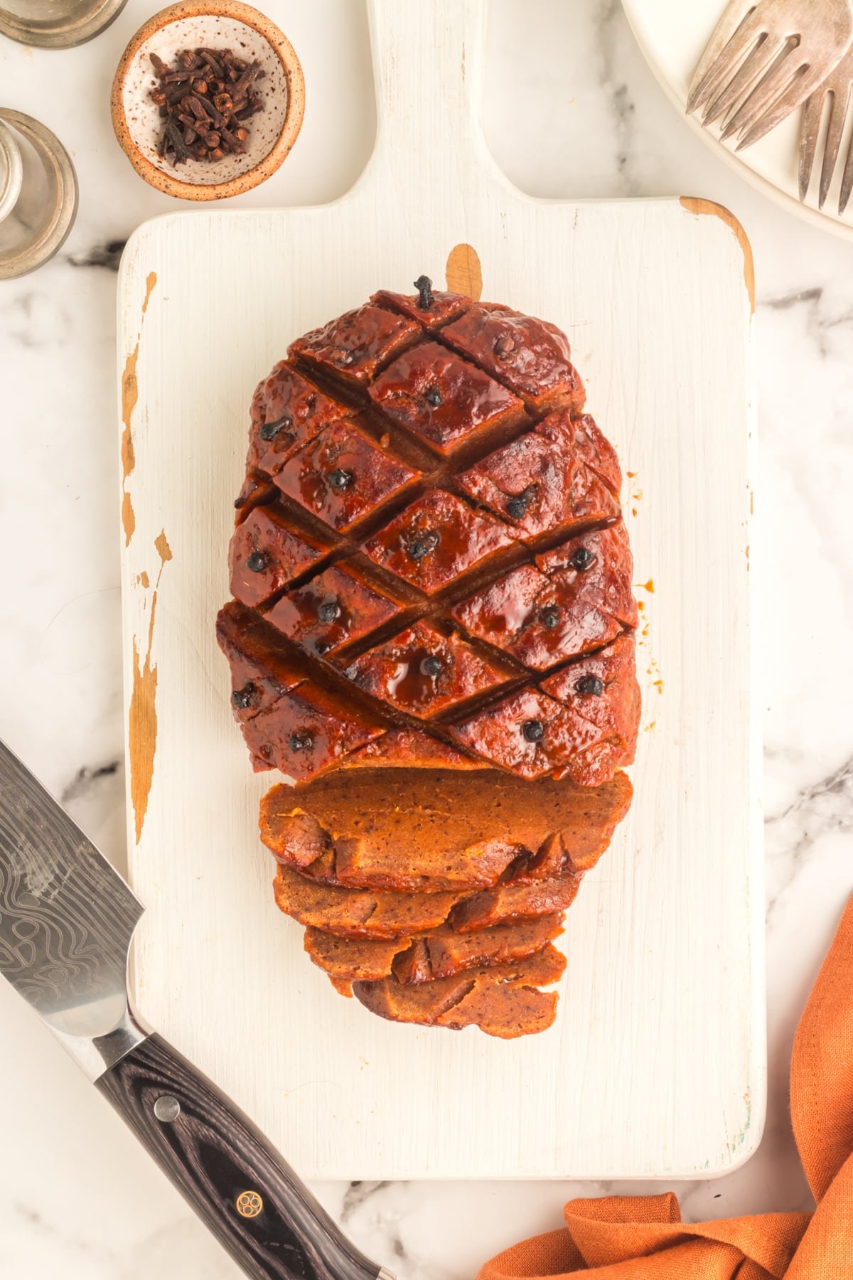 overhead view of vegan ham on a white cutting board