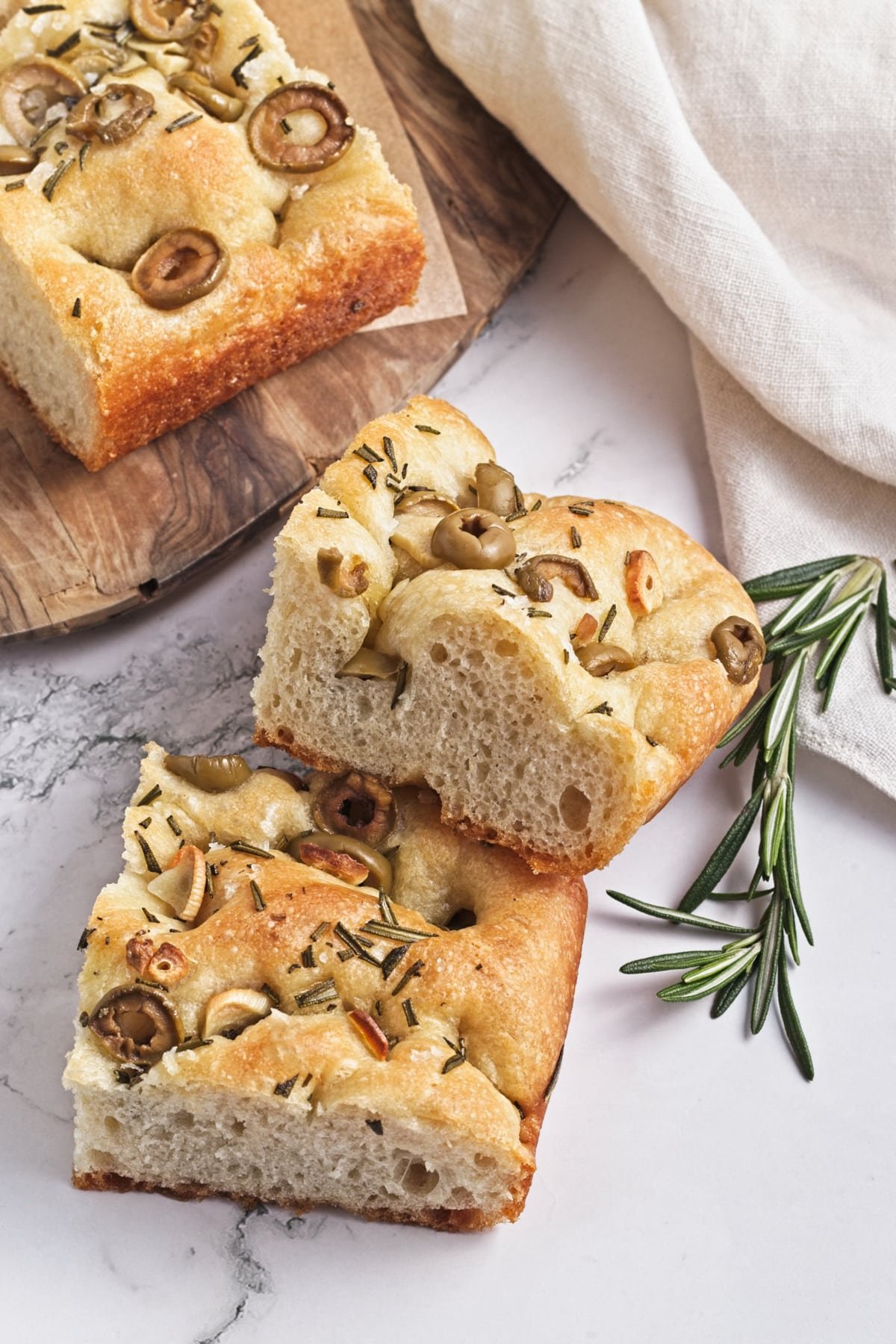 slices of garlic and rosemary focaccia recipe on a marble table