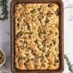 a loaf of garlic and rosemary focaccia on a baking sheet