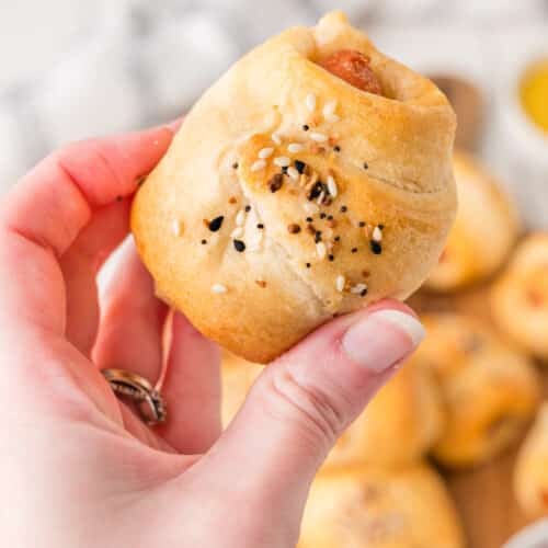 hand holding baked pigs in a blanket made with carrots