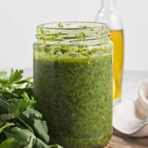 trader joe's zhoug sauce in a jar on a cutting board