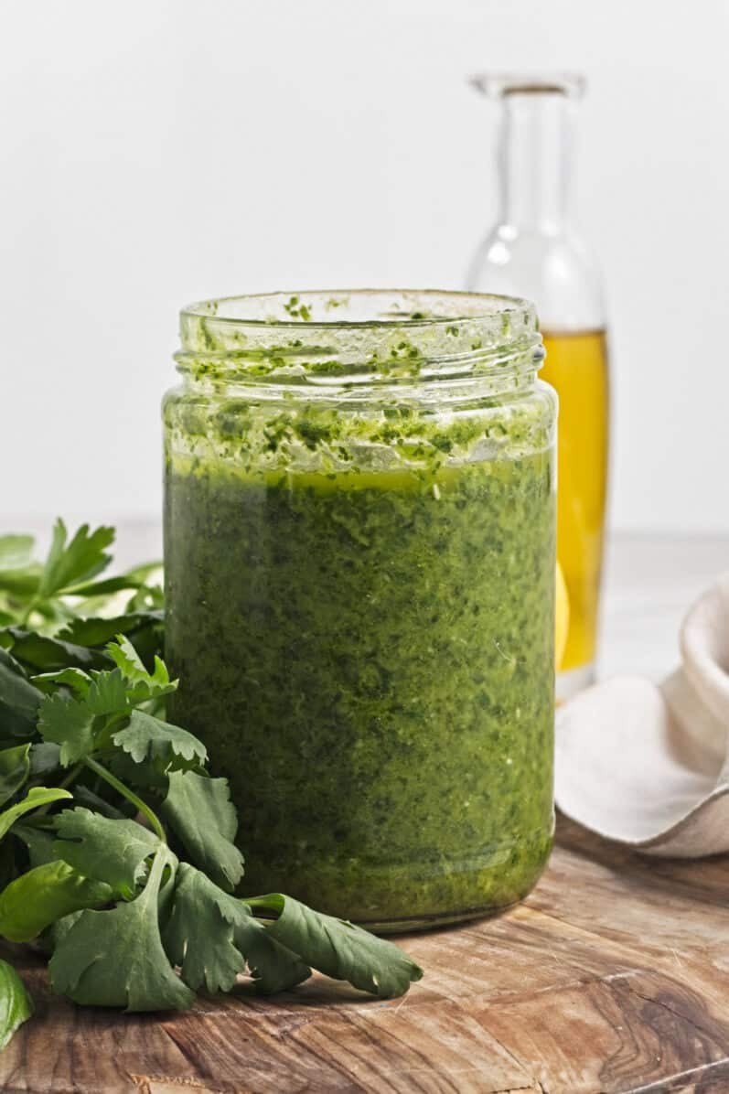 trader joe's zhoug sauce in a jar on a cutting board