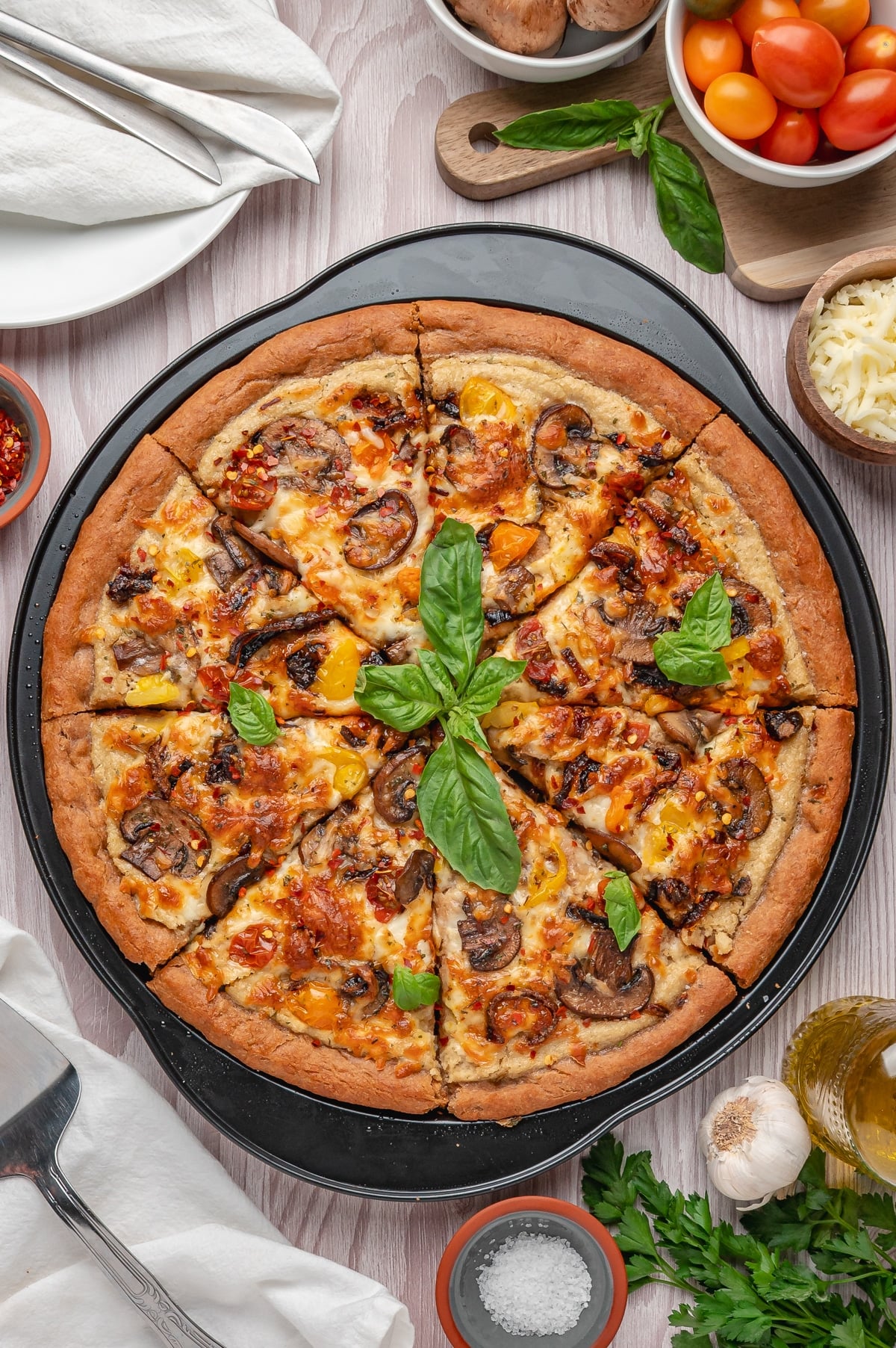 overhead view of vegan pizza topped with fresh basil after cooking