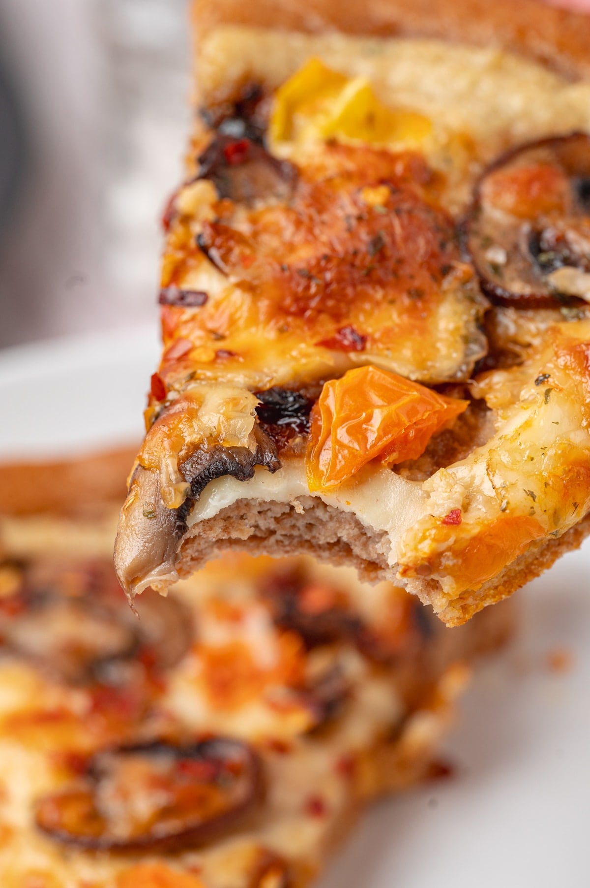 slice of vegan pizza with a bite out