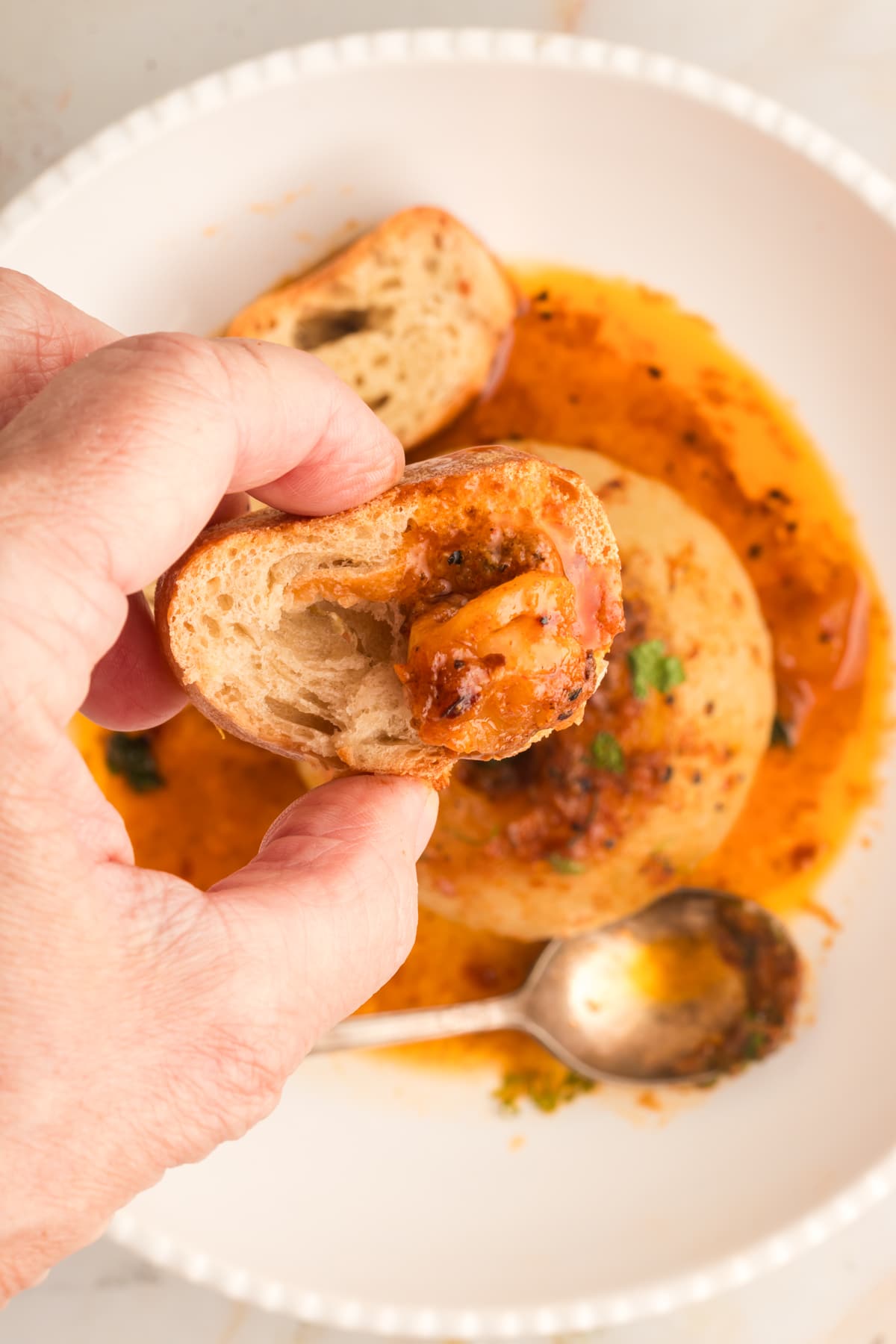 piece of bread in hand that's soaked with onion boil juices