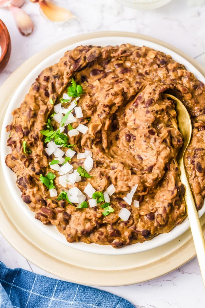 overhead view of refried vegan black beans in a white bowl